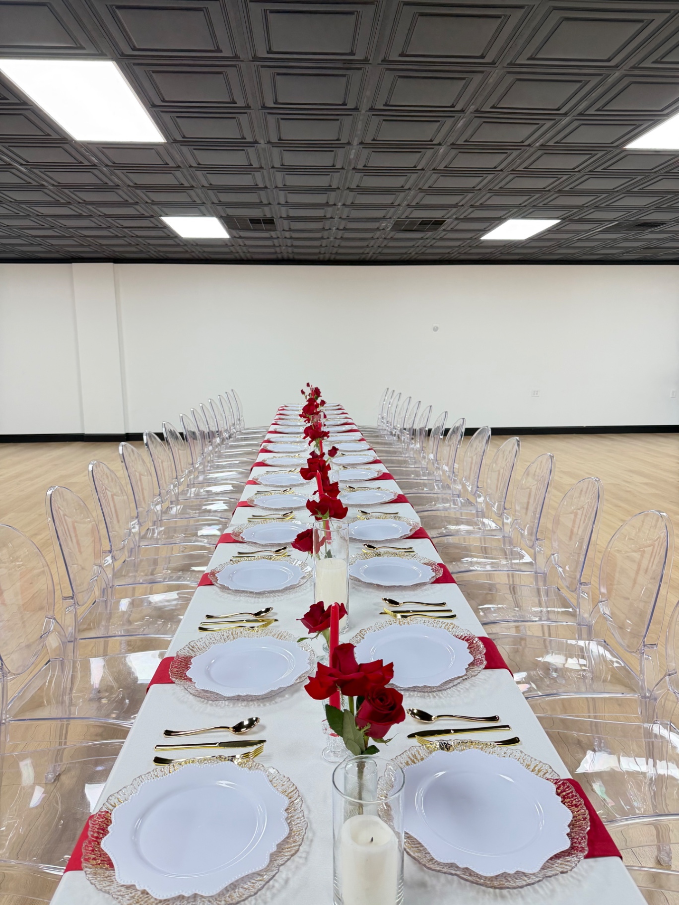 Long head table with gold flatware and red roses