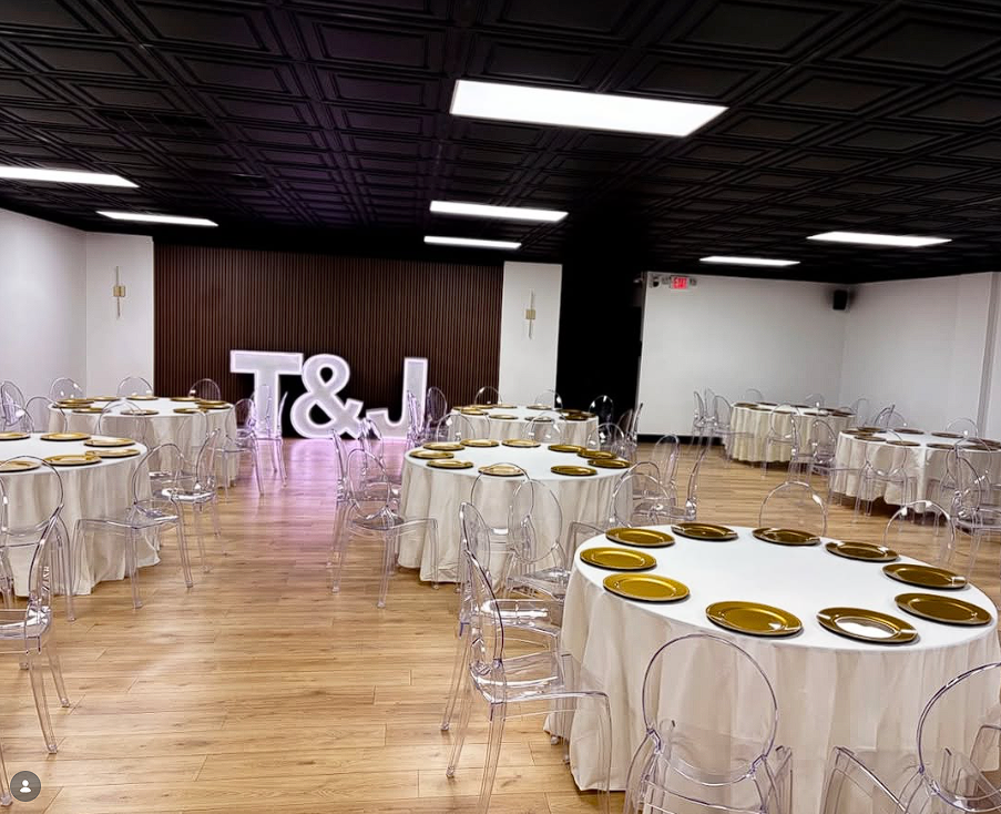 Round tables with ivory linens and gold charger plates inside Nova Loft